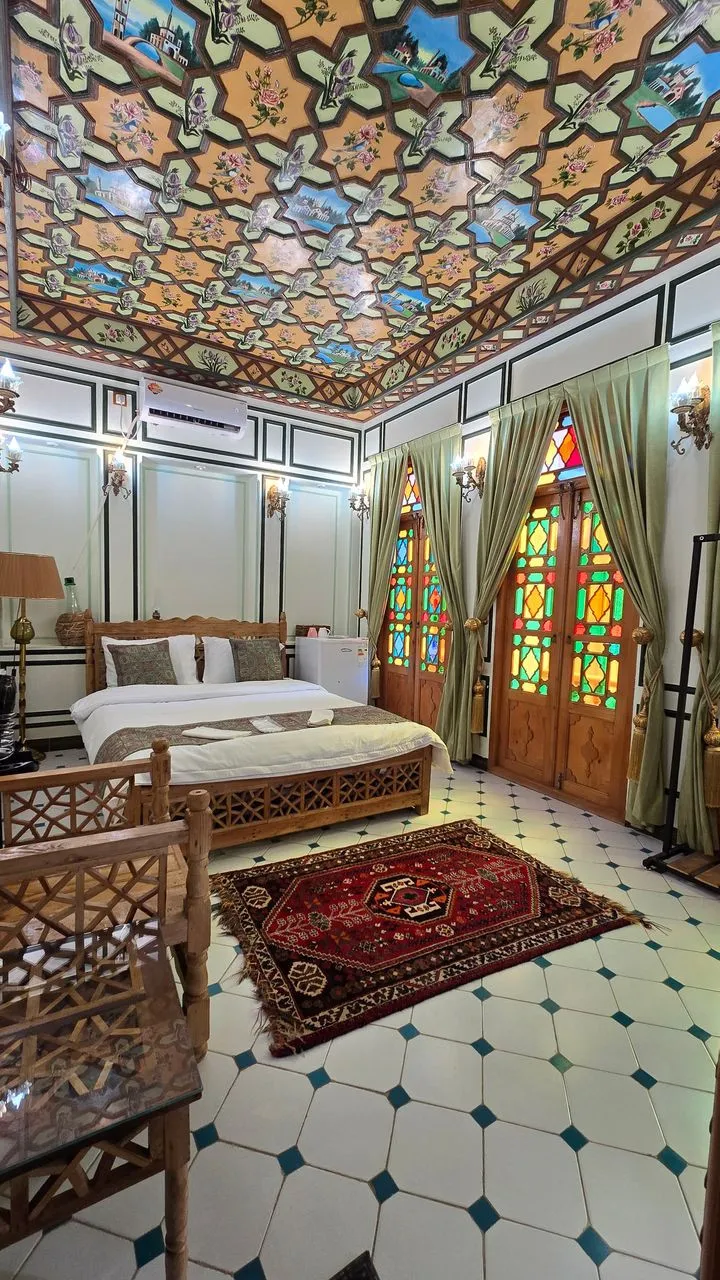 اتاق عمارت جهانشاهی با سقف نقاشیشده و پنجرههای رنگی