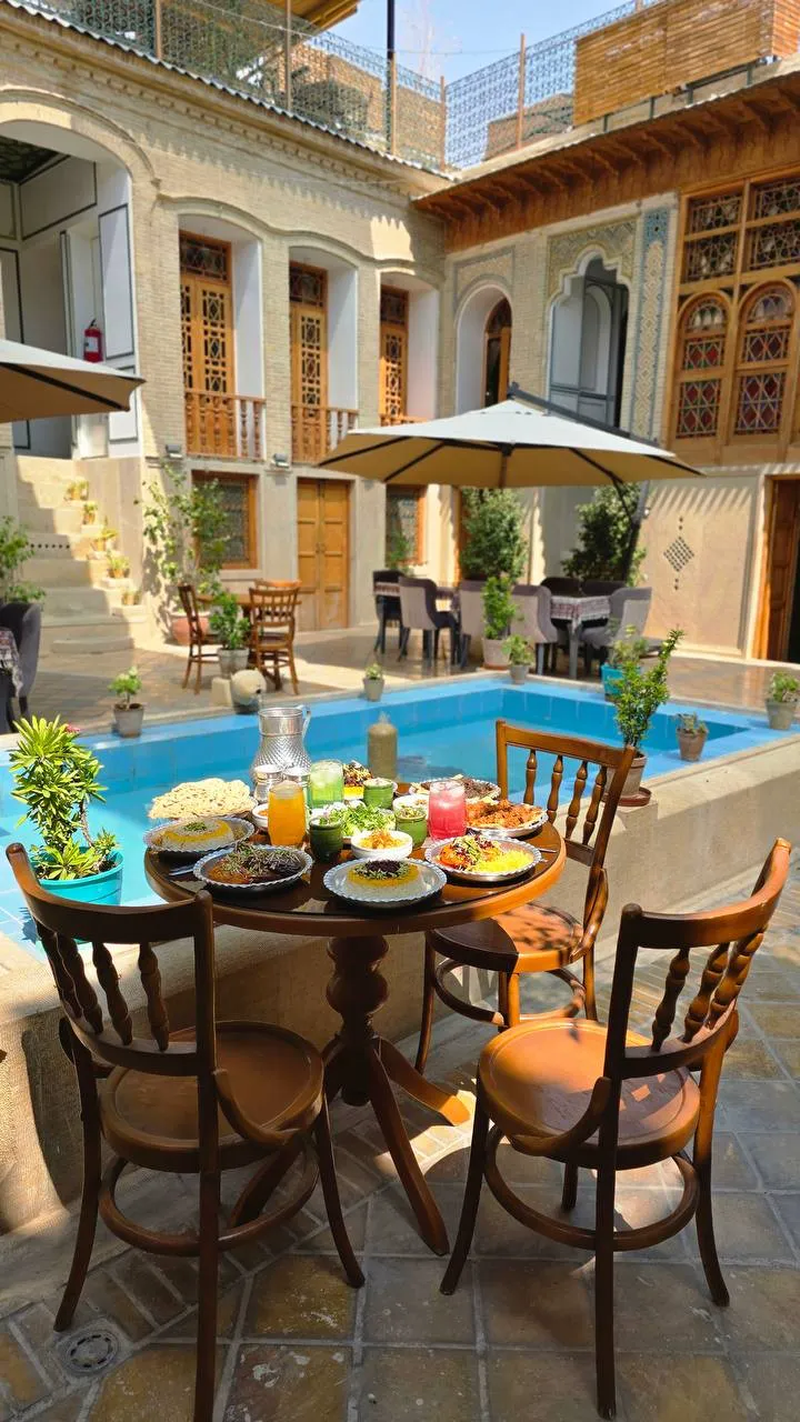 عمارت جهانشاهی با حوض و میز صبحانه