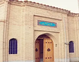 در چوبی ورودی هشت بهشت در میان دیوار آجری