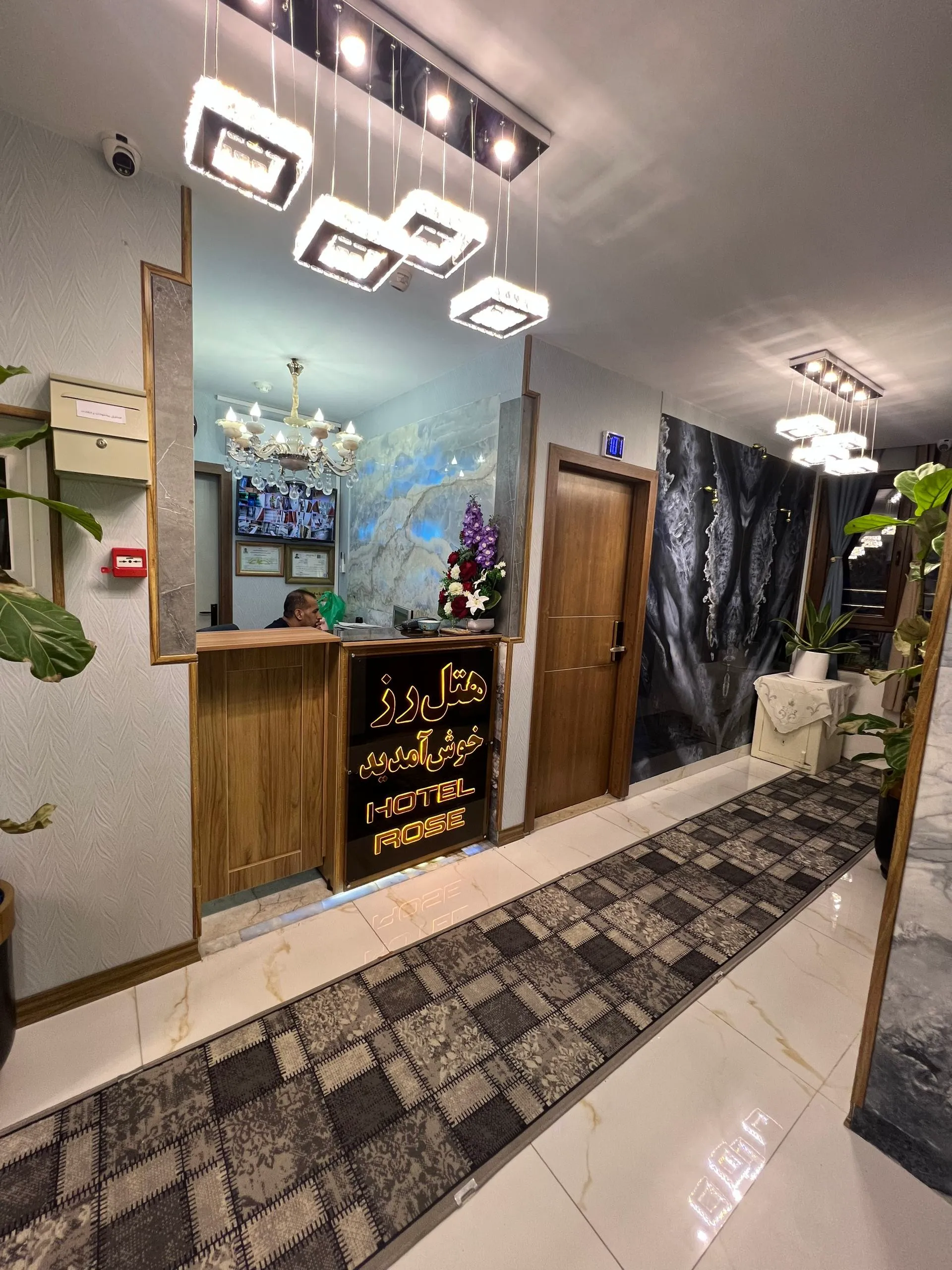 پذیرش هتل رز با میز چوبی و لوستر