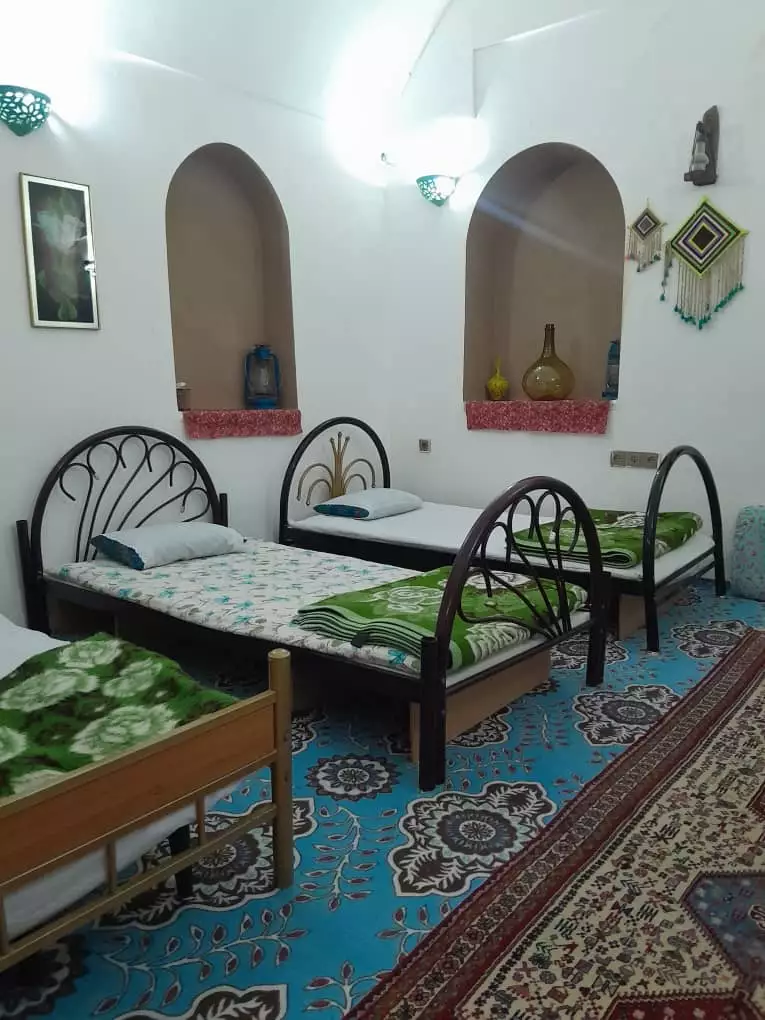 اتاق اقامتگاه هشت با تخت‌های فلزی و فرش آبی
