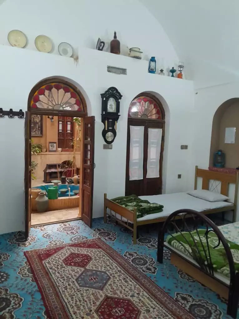 اتاق اقامتگاه هشت با تخت چوبی و درهای قوسی