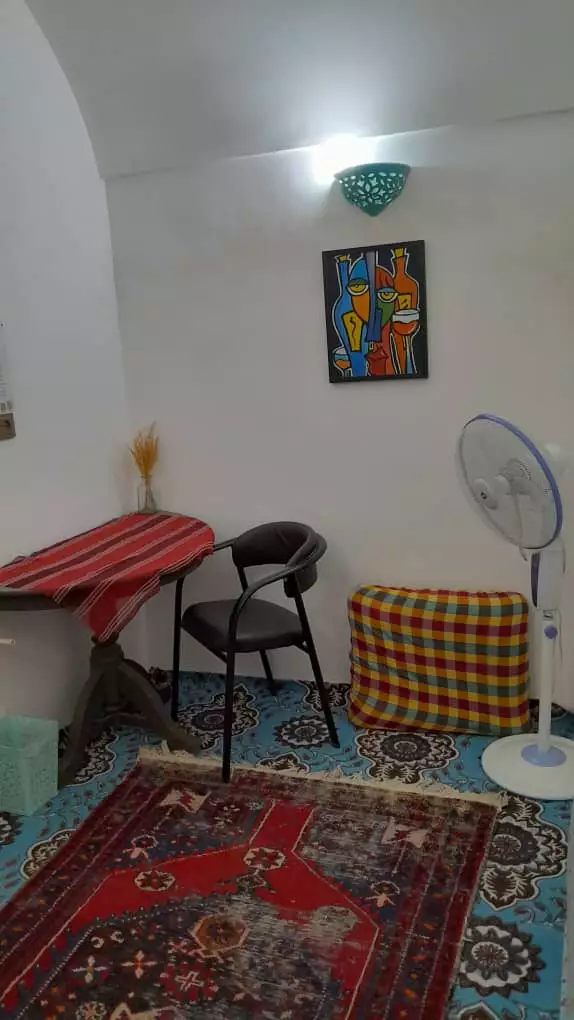 فضای نشیمن هتل هشت با فرش و پنکه