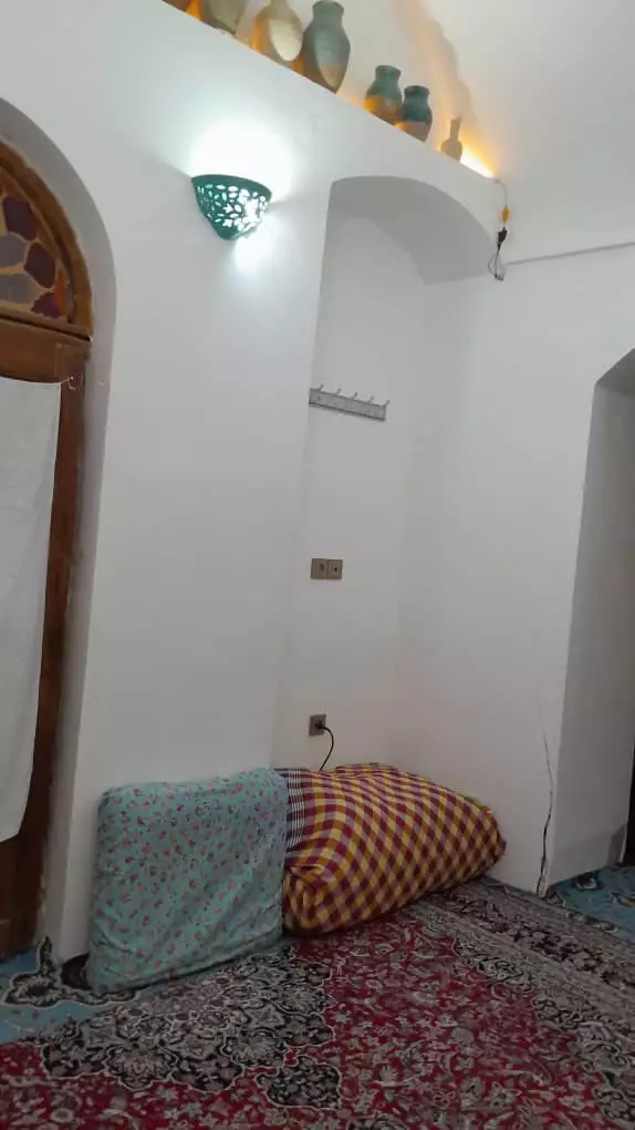 گوشه اتاق هتل هشت با پشتی و فرش ایرانی