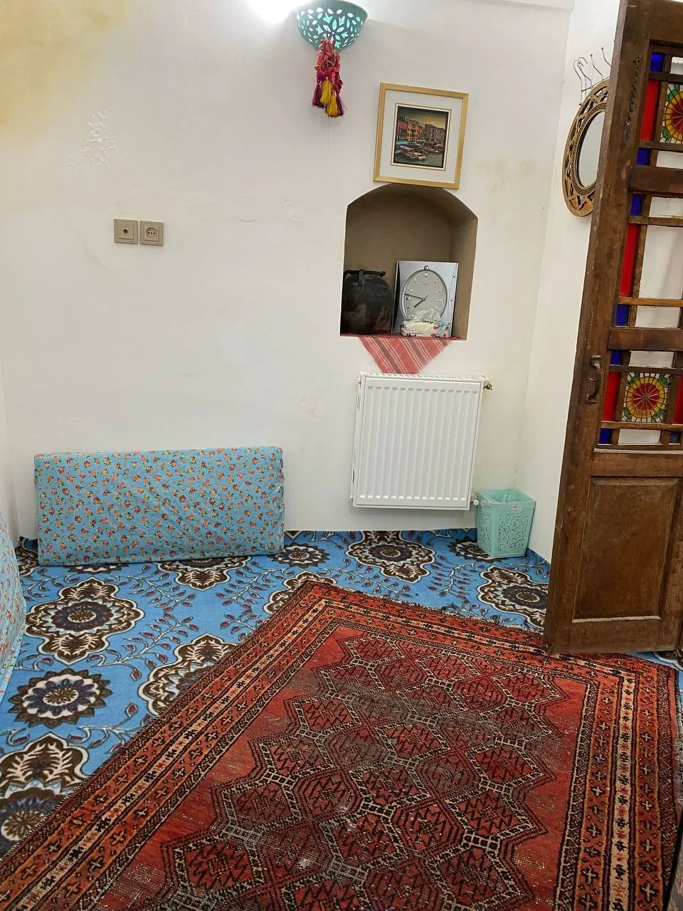 گوشه اتاق سنتی هتل هشت با قالی قرمز