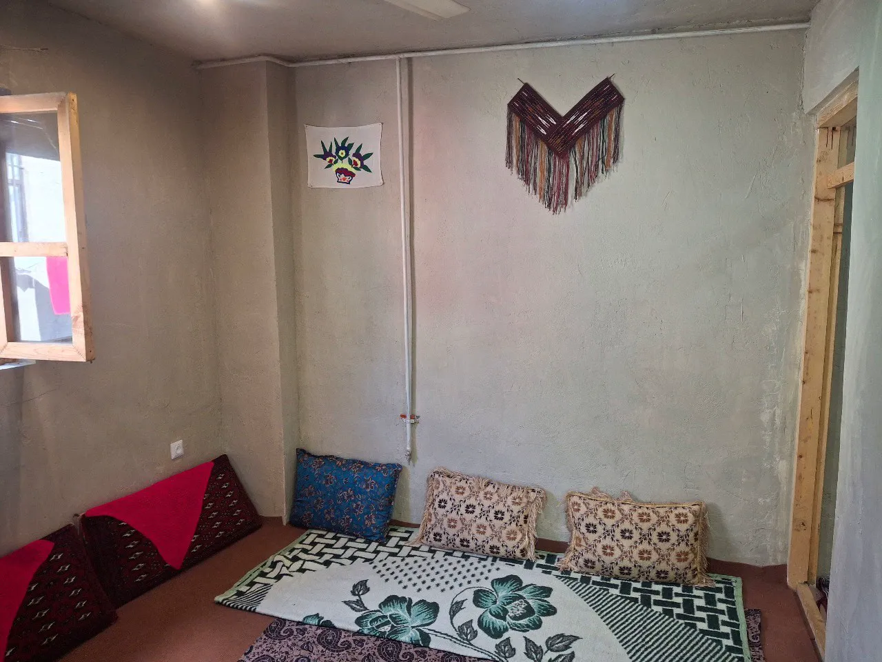 رختخواب سنتی با بالش‌های طرح‌دار در اتاق عمو رضا