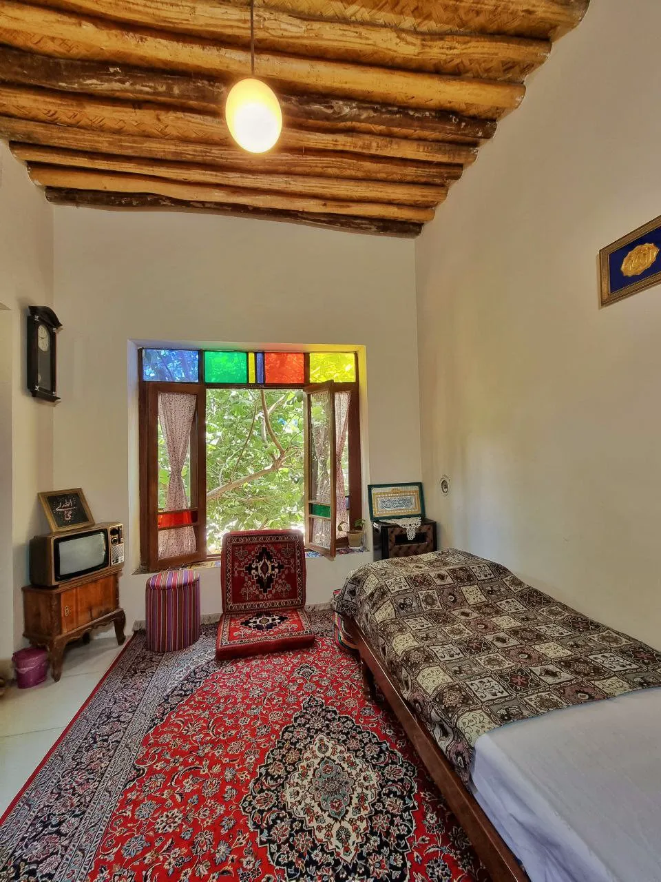 اتاق سنتی ماه سلطان با سقف چوبی و پنجره رنگی