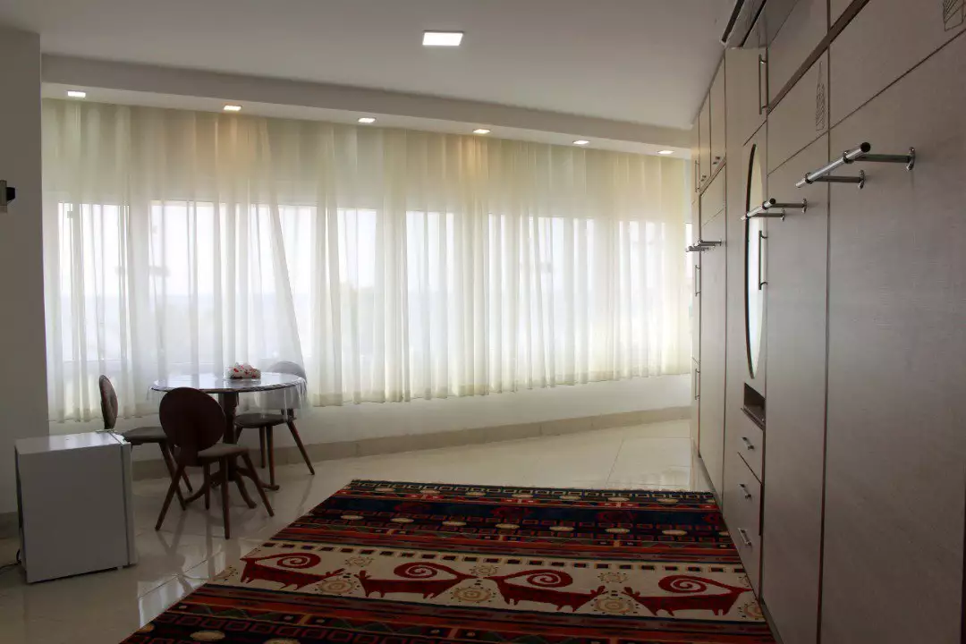 میز و صندلی کنار پنجره در اتاق هتل هرموز