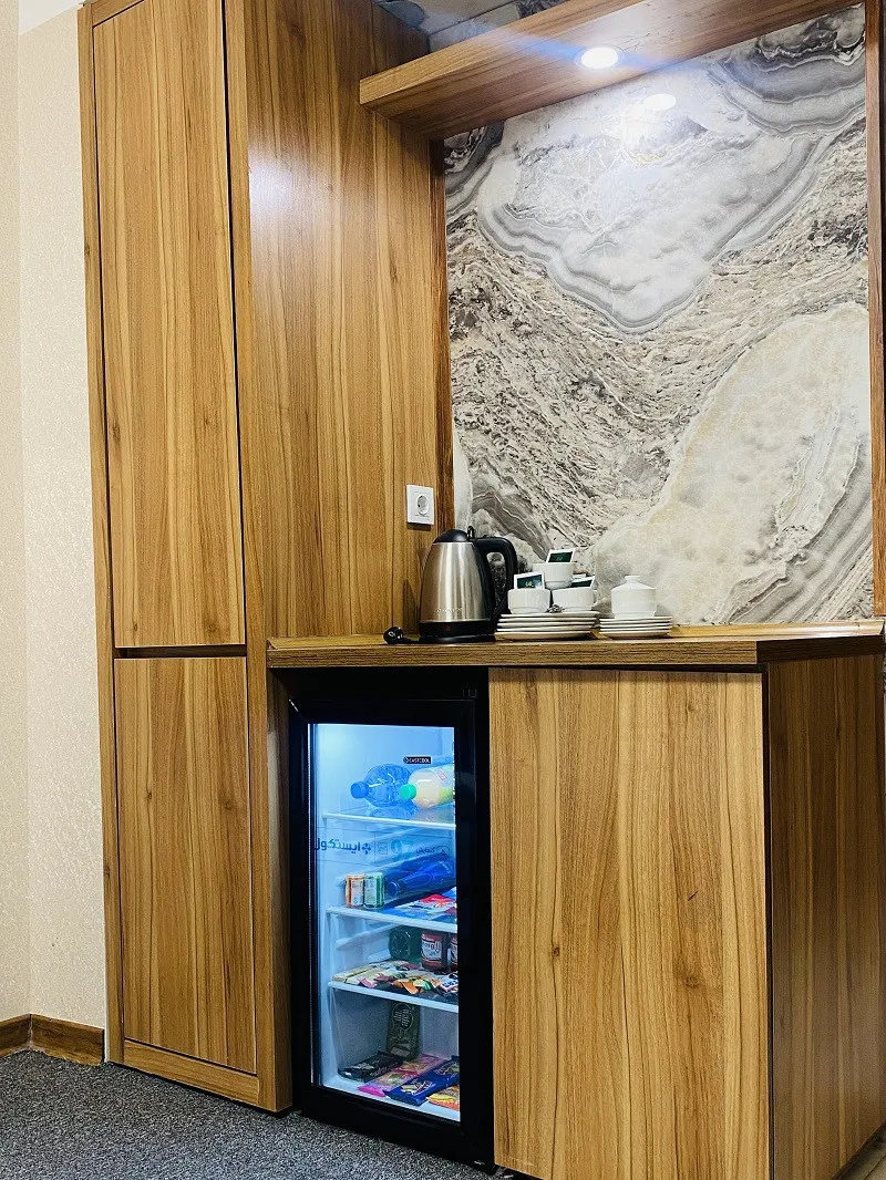 مینیبار یخچالدار و کتری در اتاق هتل ضیافت نور