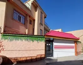 نمای بیرونی هتل توکا با در ورودی و سایبان قرمز