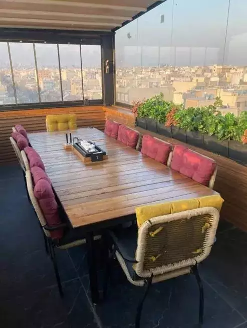 میز چوبی کنار پنجره با چشمانداز شهر در هتل نیکان مهر