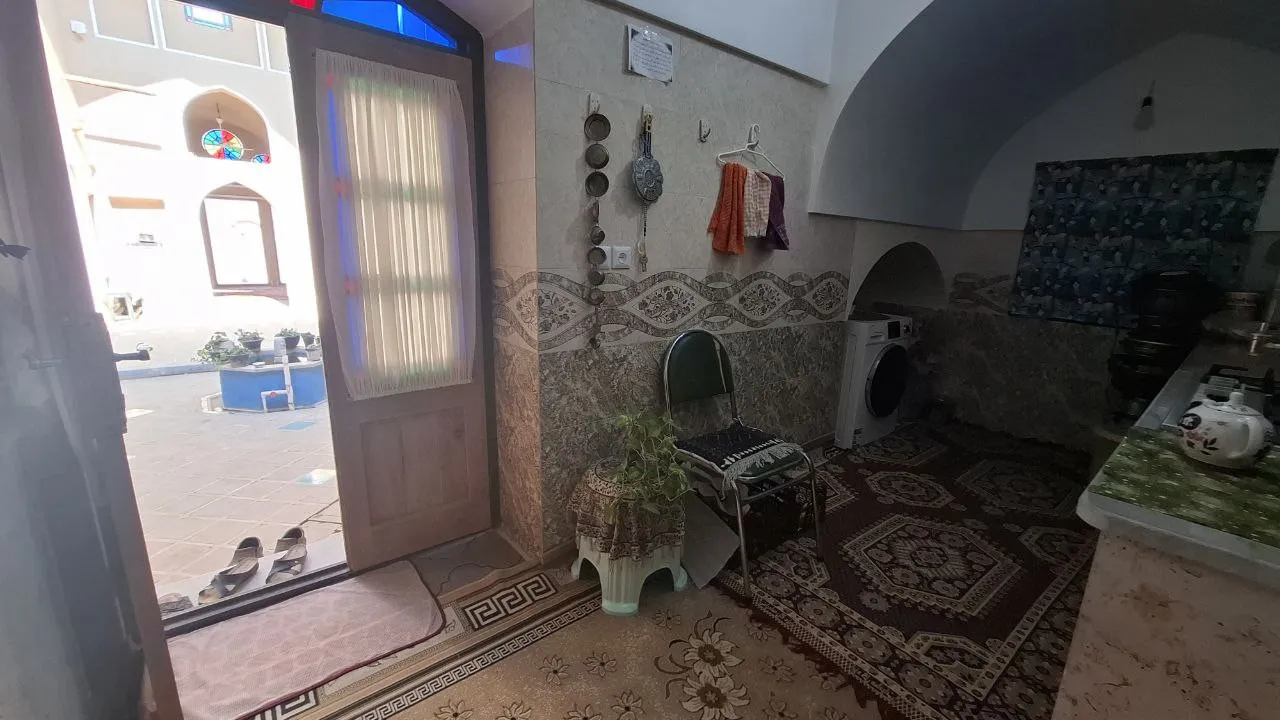 فضای داخلی با در ورودی باز و فرشهای طرحدار استاد حسین اردکانی