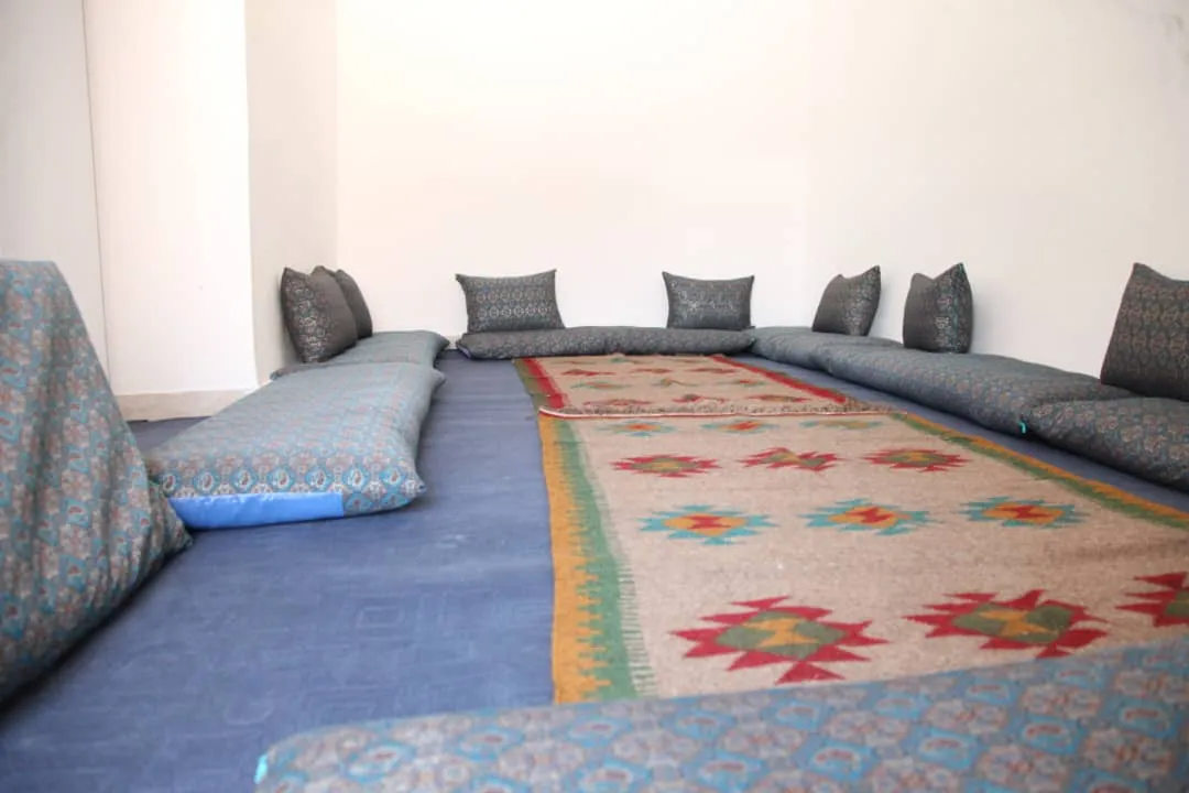 چیدمان پشتی‌های سنتی و قالی در خانه خشتی