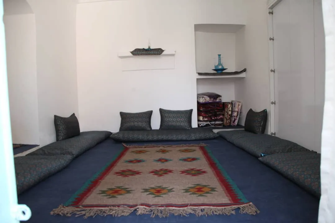 اتاق نشیمن خانه خشتی با فرش طرح‌دار