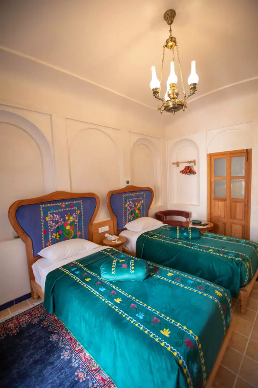 اتاق دوتخته با روتختی سبز گلدوزیشده عمارت آقاحسینی