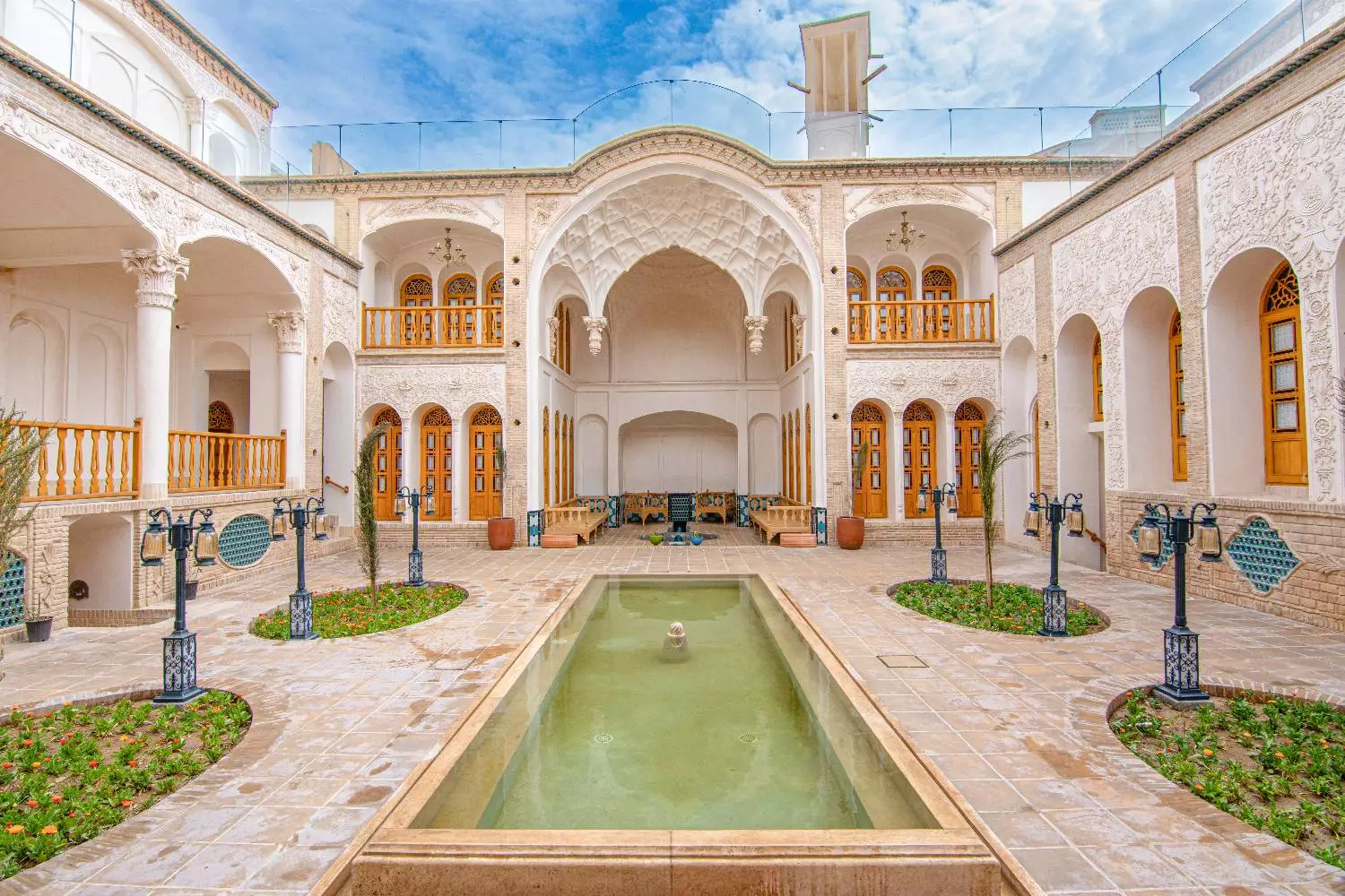 حیاط عمارت آقاحسینی با حوض مستطیلی و طاق‌های ایرانی