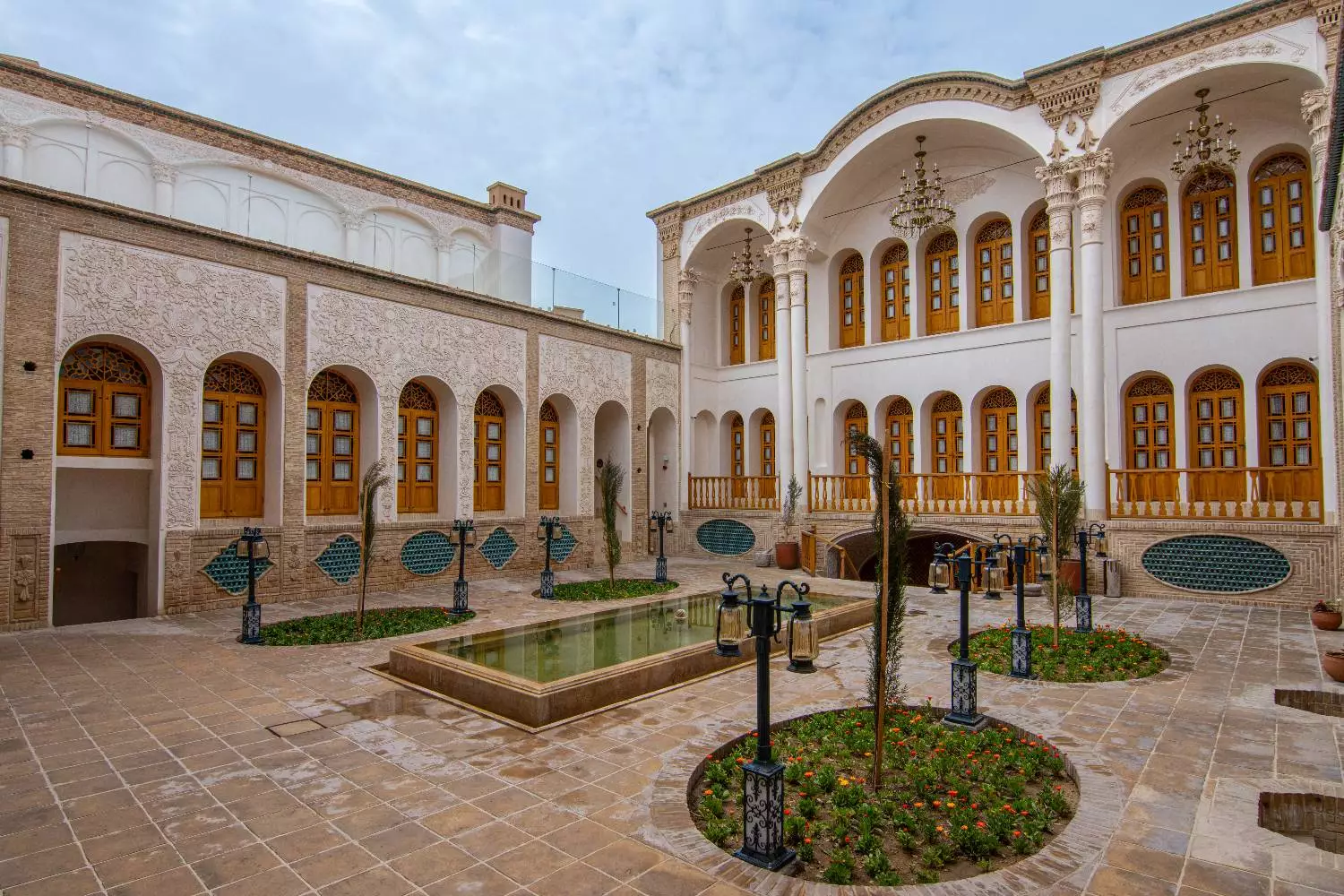 حیاط عمارت آقاحسینی با حوض و پنجره‌های چوبی