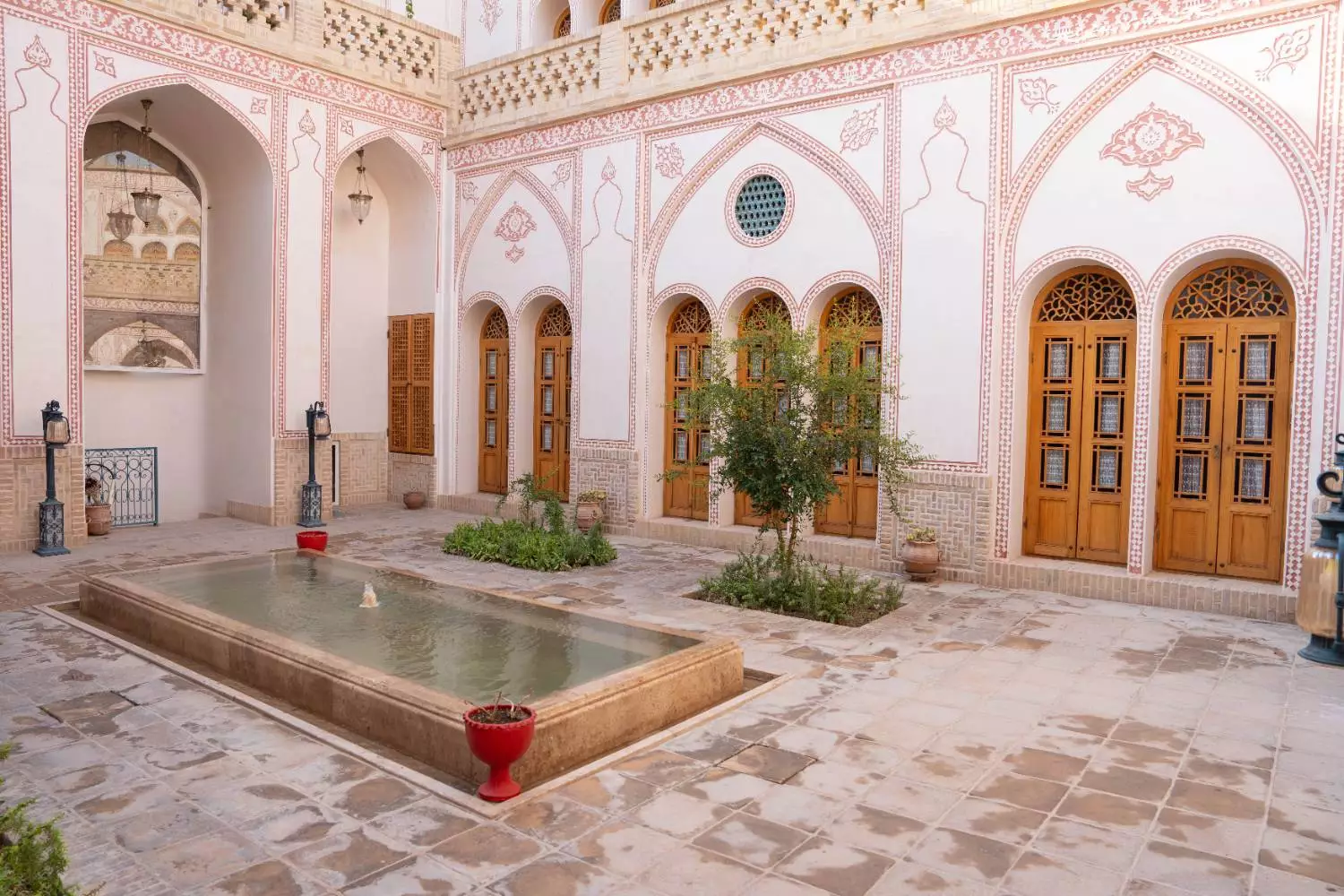 حیاط عمارت آقاحسینی با حوض و پنجره‌های چوبی