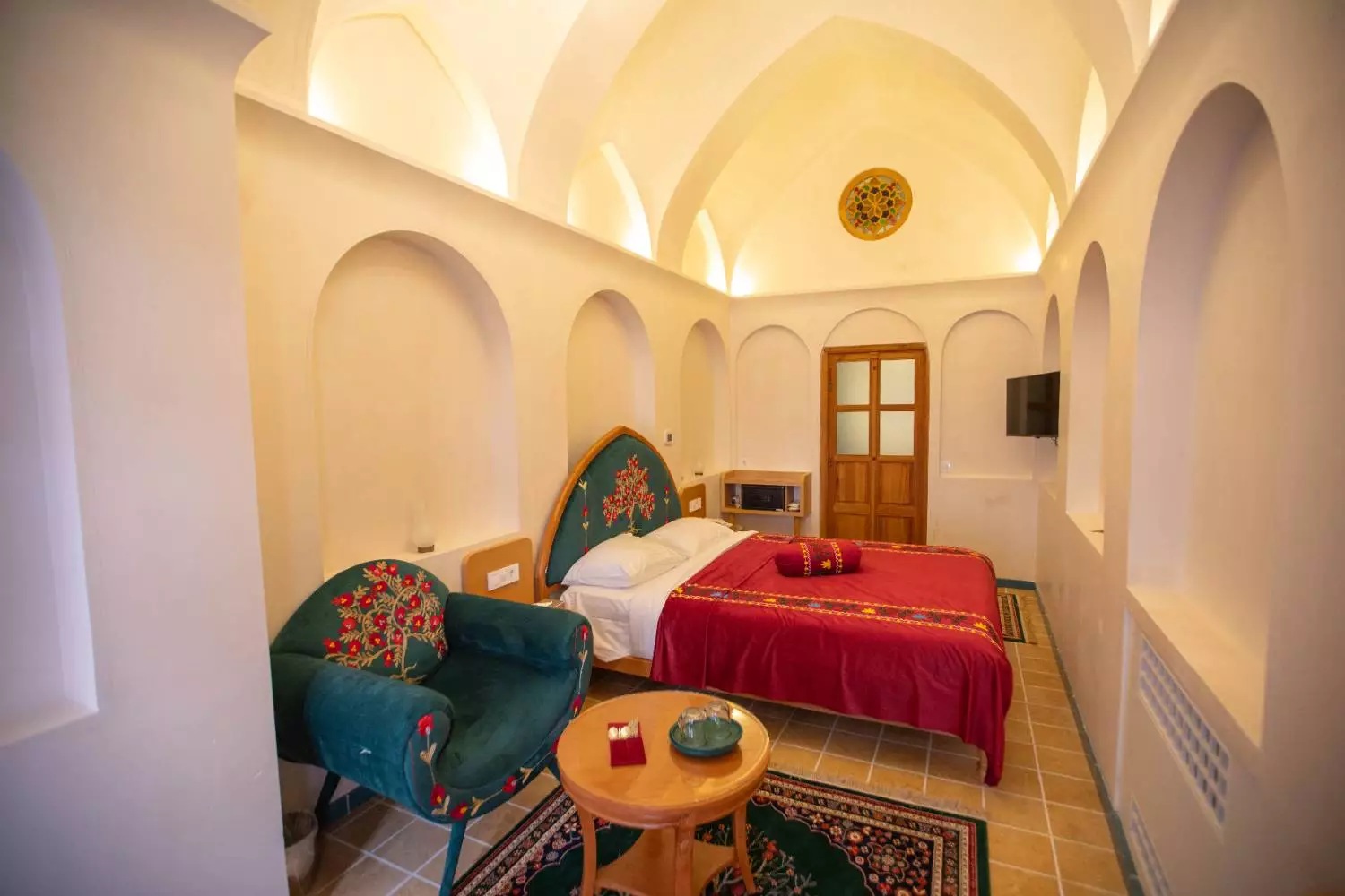 اتاق عمارت آقاحسینی با تخت قرمز و سقف گنبدی