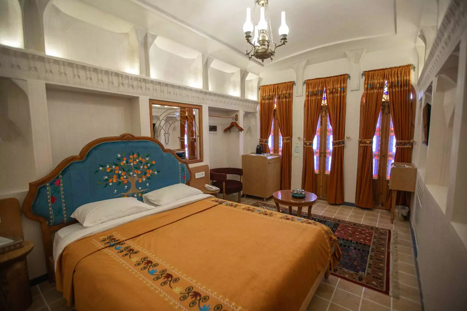 اتاق عمارت آقاحسینی با تخت و پردههای نارنجی