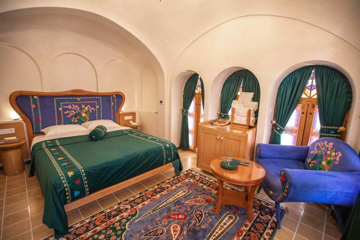 اتاق عمارت آقاحسینی با تخت سبز و قالی ایرانی