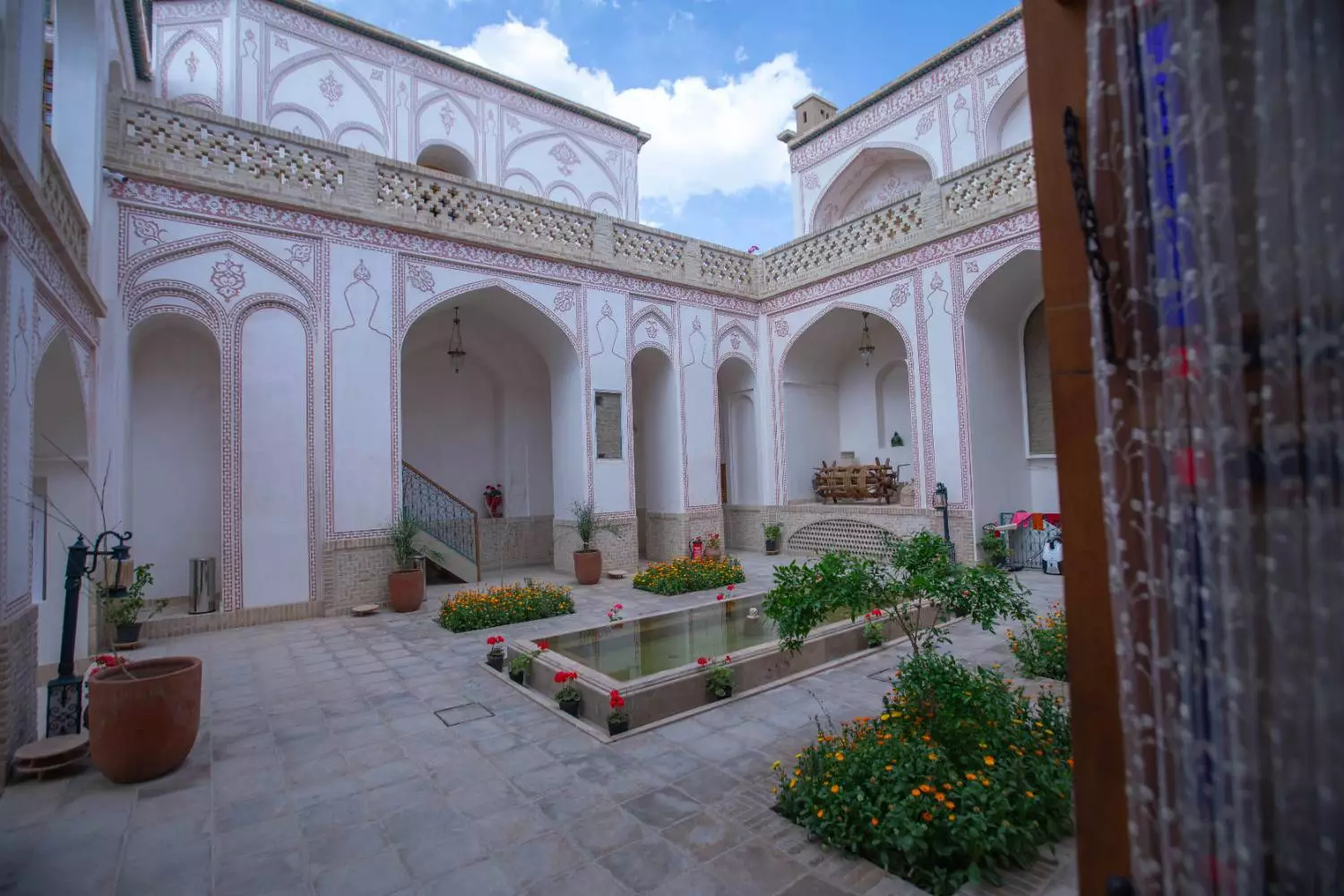 حیاط گلکاریشده عمارت آقاحسینی با ایوانهای قوسی