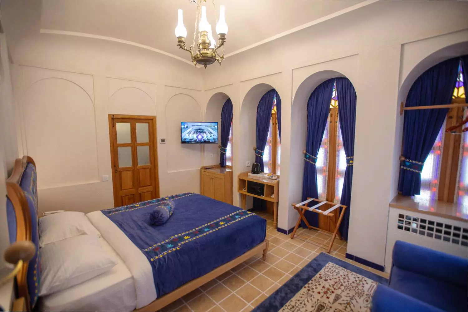 اتاق عمارت آقاحسینی با تخت دونفره و پنجرههای قوسی