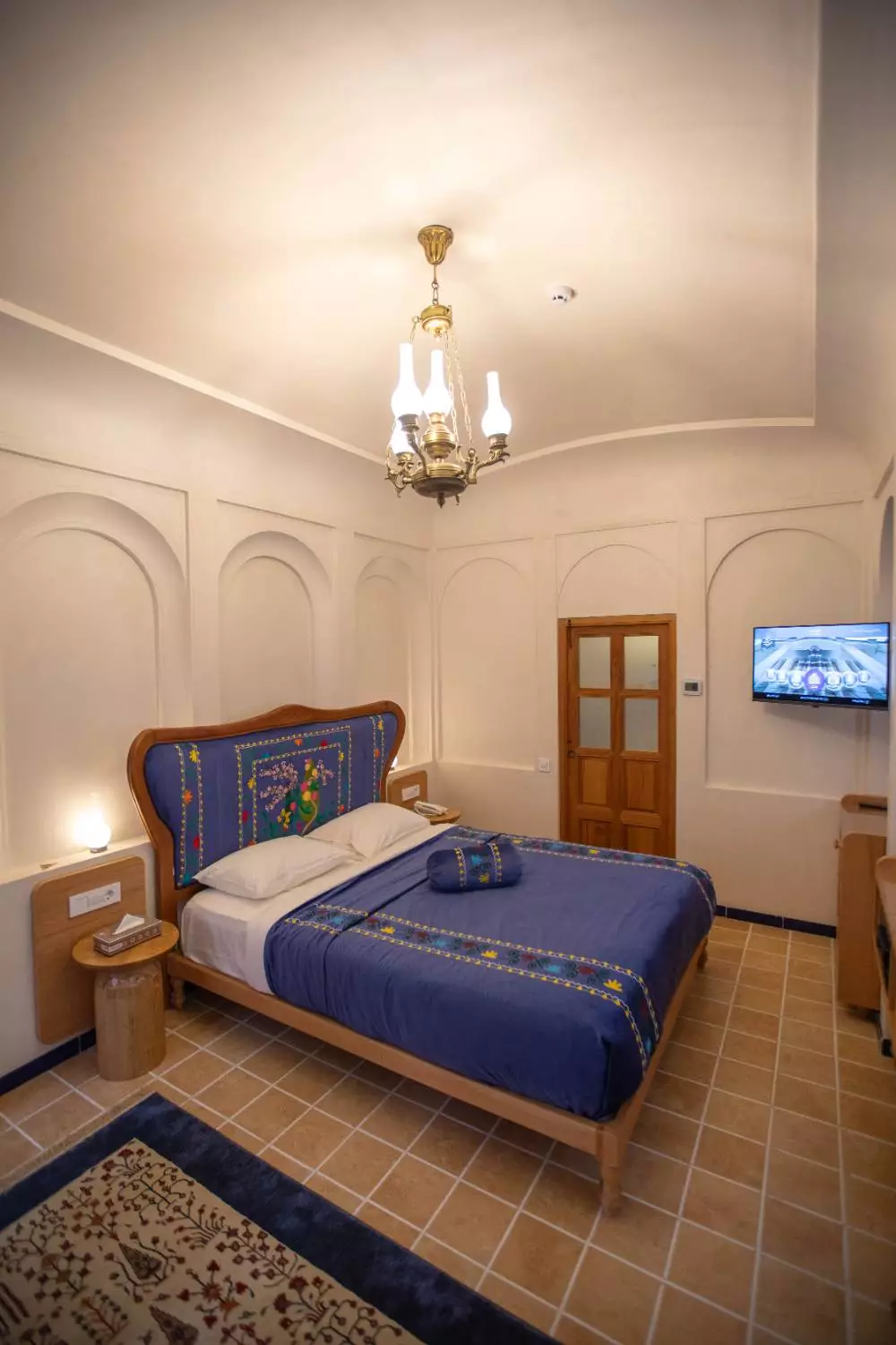تخت دونفره اتاق عمارت آقاحسینی با روتختی آبی