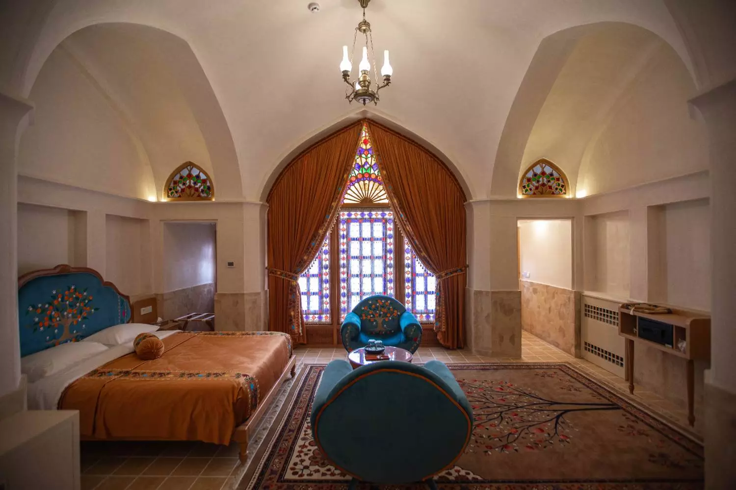 اتاق عمارت آقاحسینی با تخت و پنجره شیشهرنگی