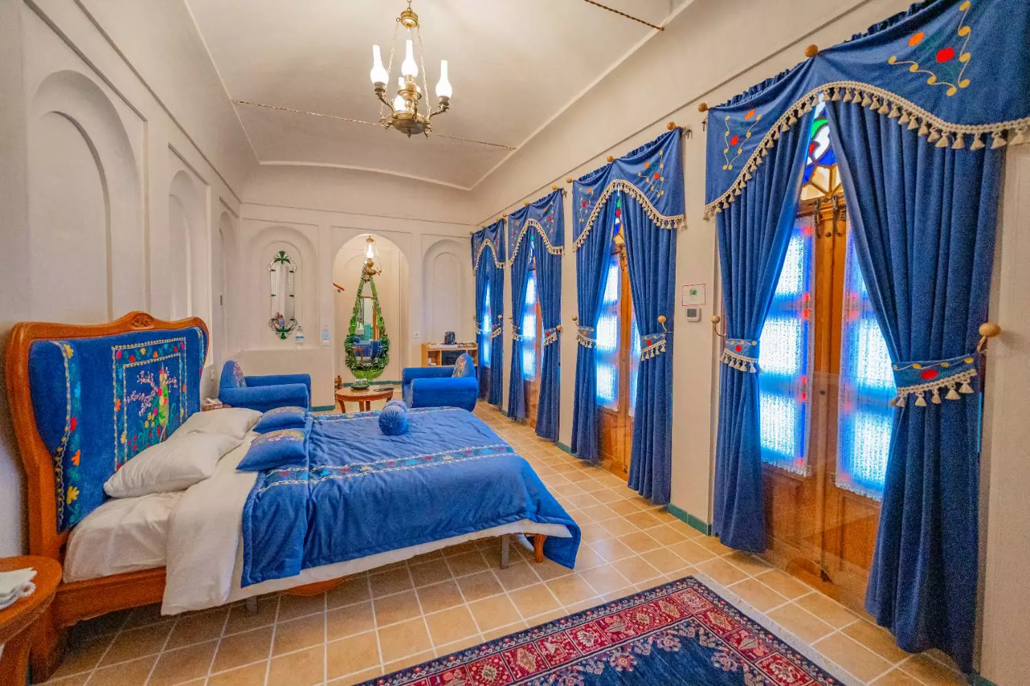 تخت آبی کنار پنجرههای بلند عمارت آقاحسینی