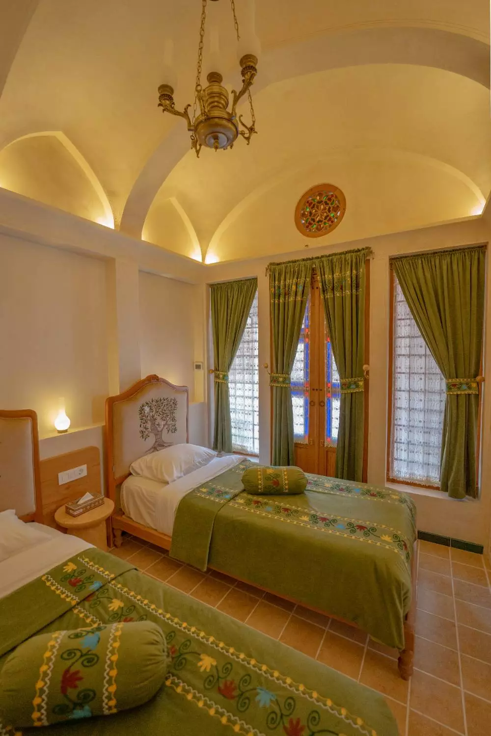 دو تخت با روتختی سبز در اتاق عمارت آقاحسینی