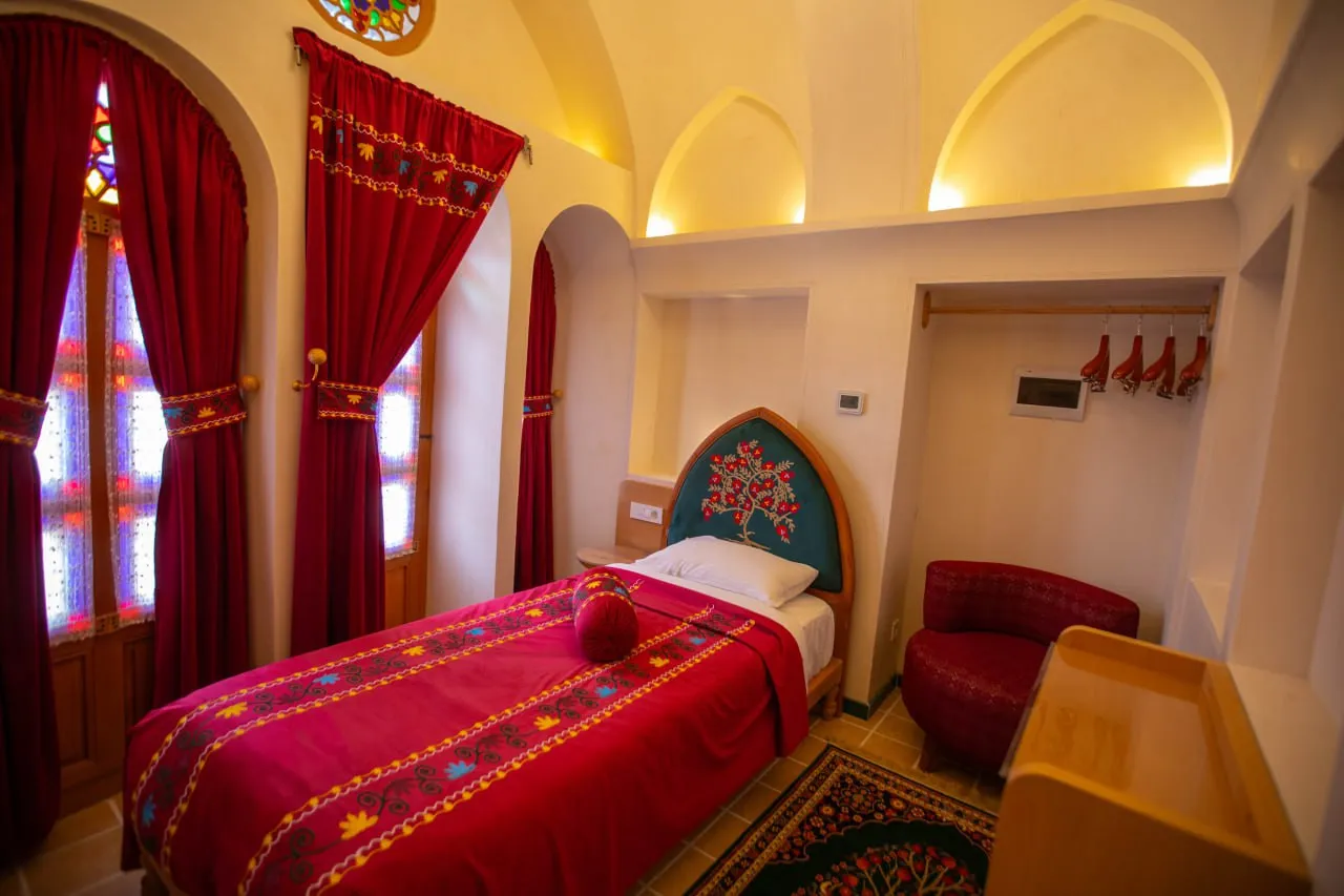 تخت سرخ کنار پنجرههای رنگی عمارت آقاحسینی