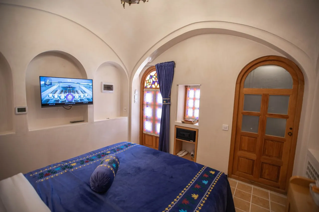اتاق عمارت آقاحسینی با تخت آبی و در چوبی