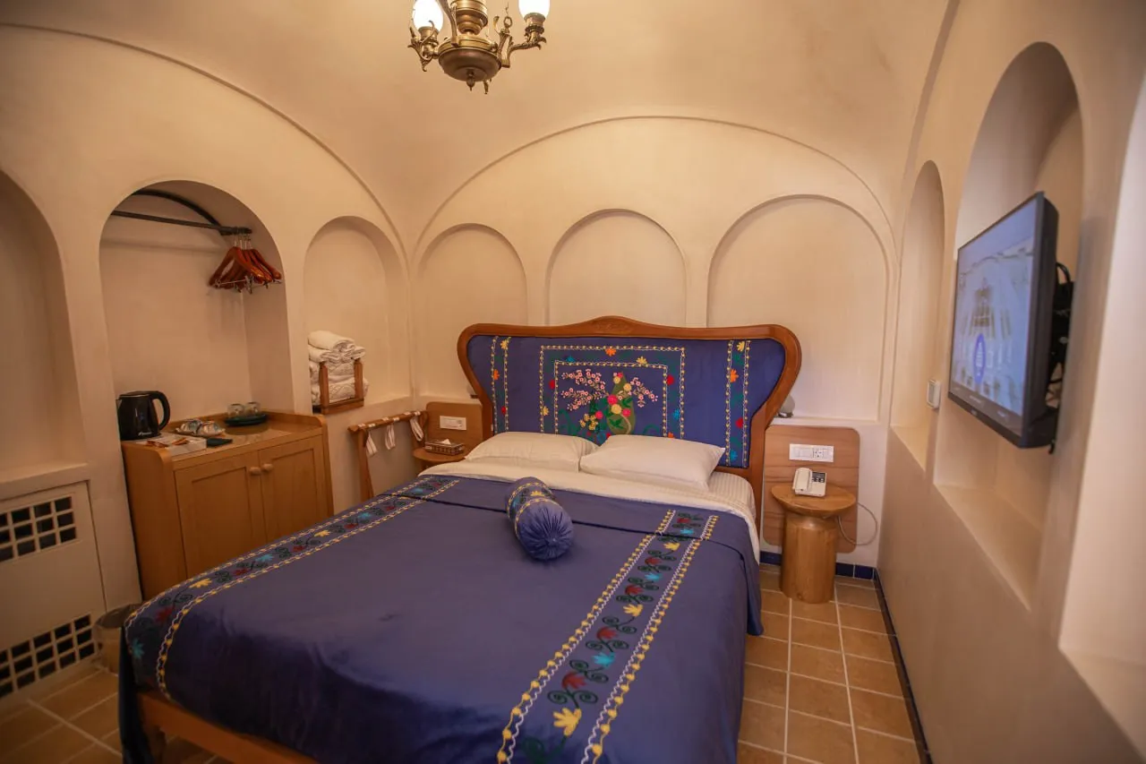 تخت دونفره با روتختی آبی در عمارت آقاحسینی
