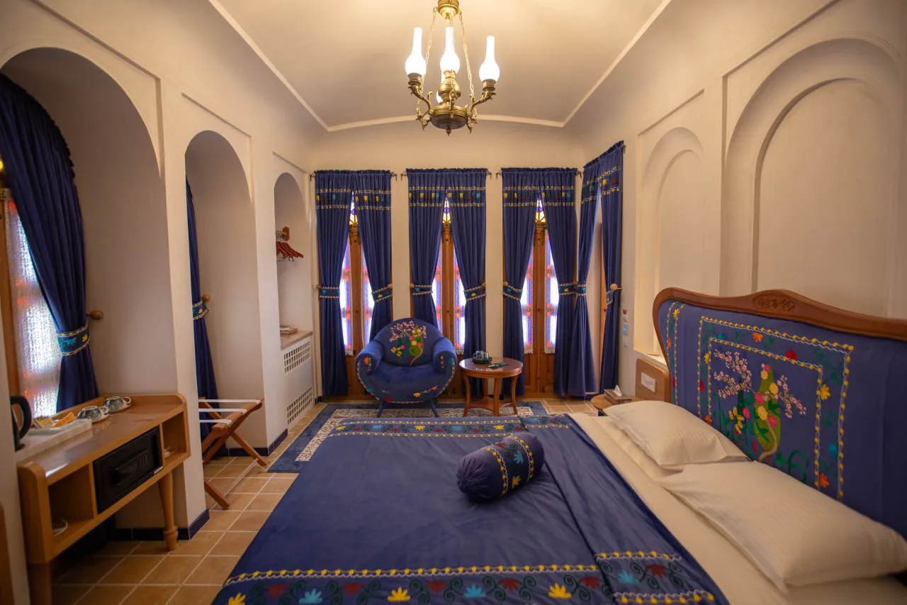 تخت آبی گلدوزیشده در اتاق عمارت آقاحسینی