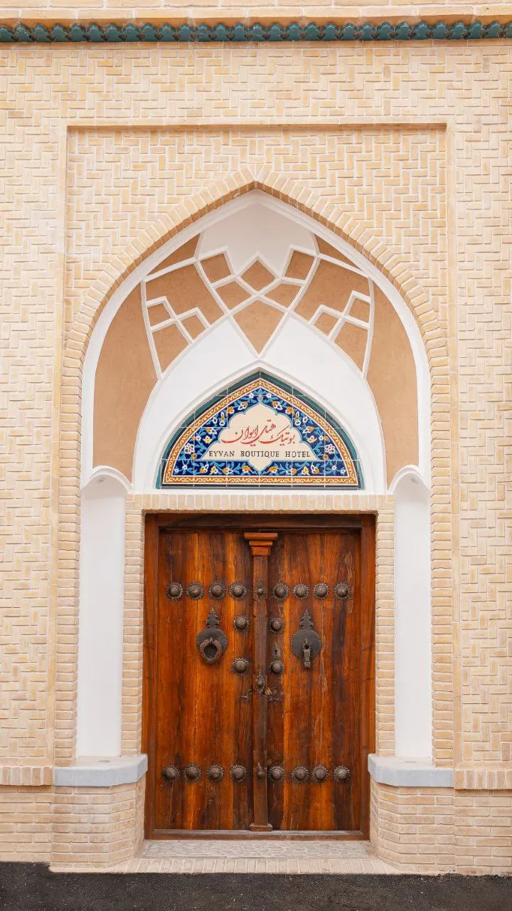 در چوبی ورودی هتل ایوان در قاب کاشی‌کاری