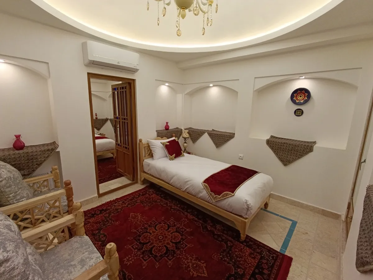 تخت یک‌نفره کنار فرش سرخ در عمارت شمسه