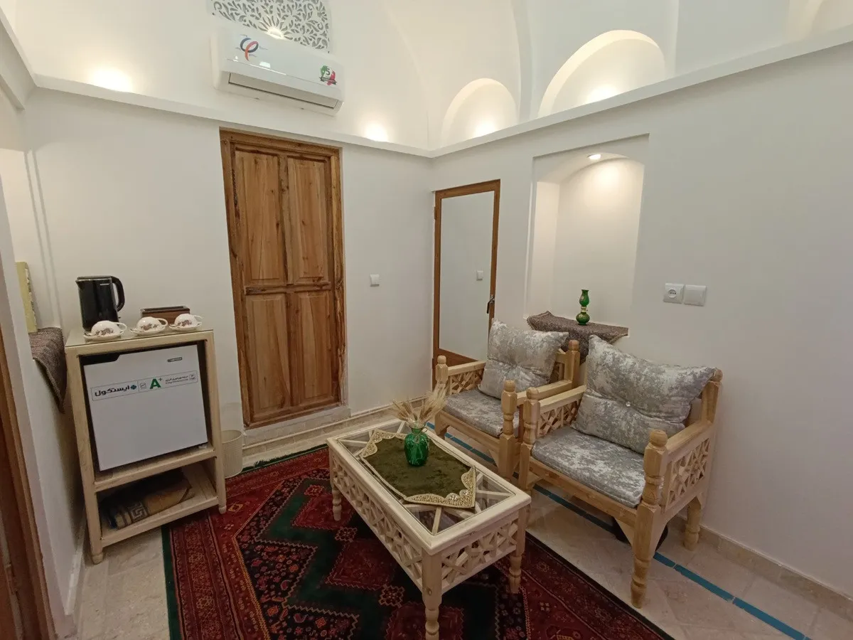 نشیمن عمارت شمسه با مبل چوبی و فرش