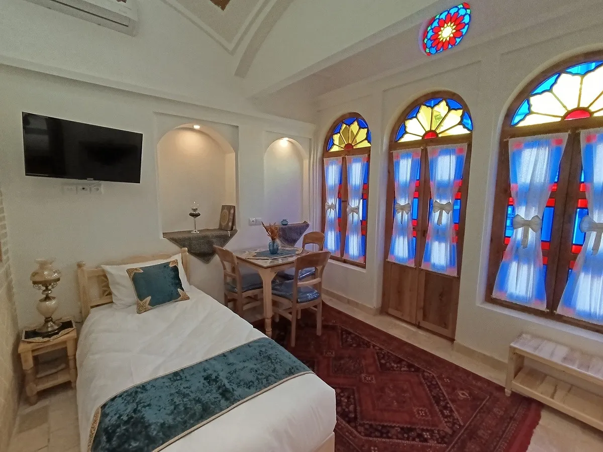 اتاق عمارت شمسه با پنجره‌های رنگی و تخت