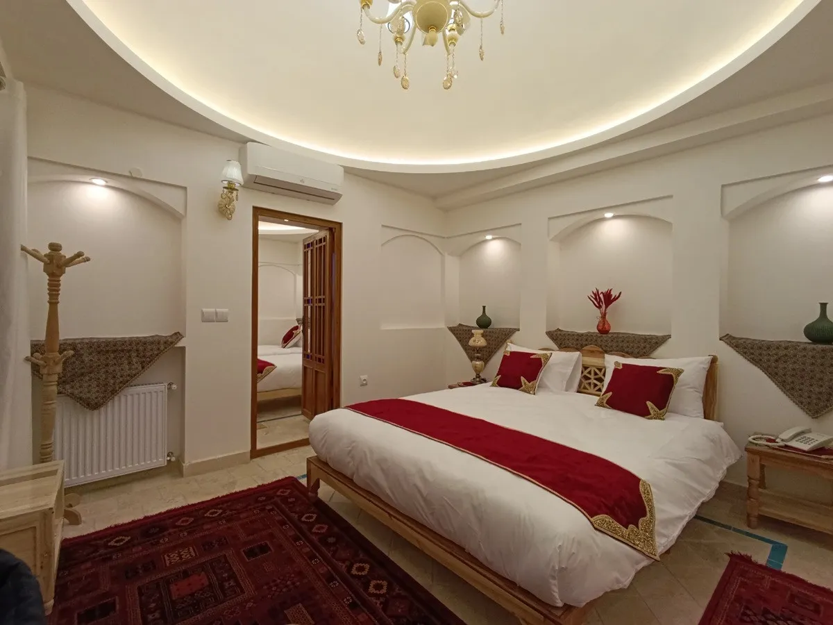 تخت دونفره با روتختی سرخ در عمارت شمسه