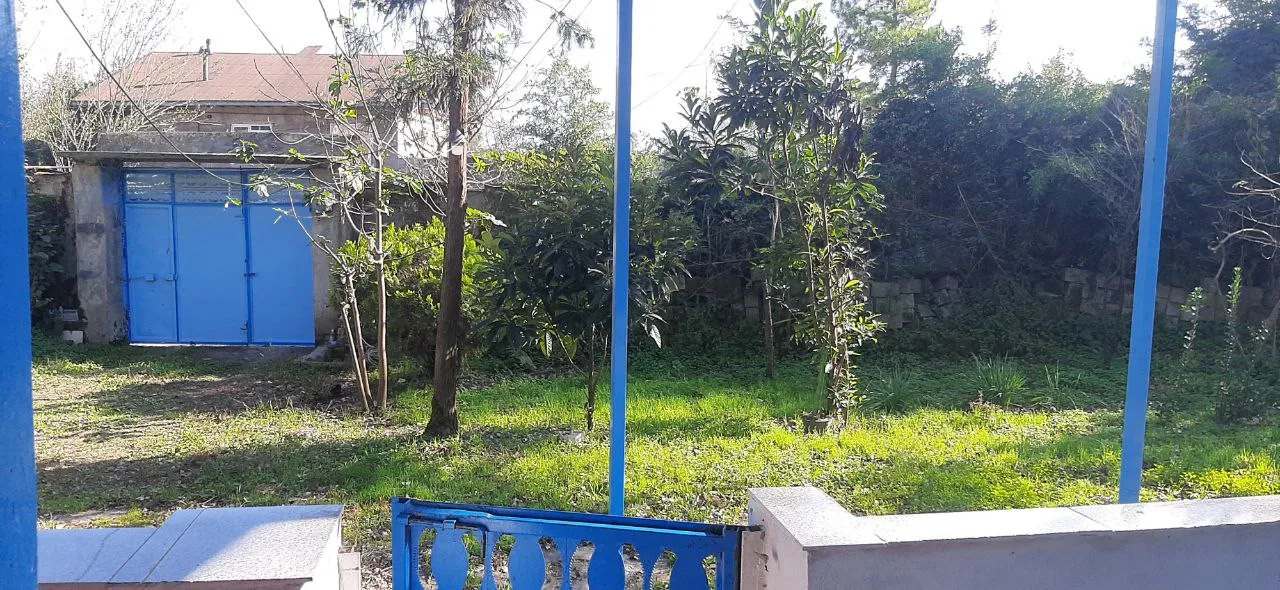 حیاط سرسبز اقامتگاه کارن با دروازه آبی