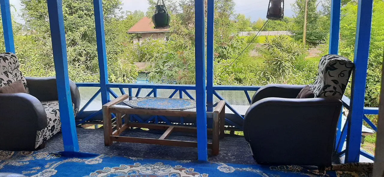 ایوان اقامتگاه کارن با صندلی و میز چوبی