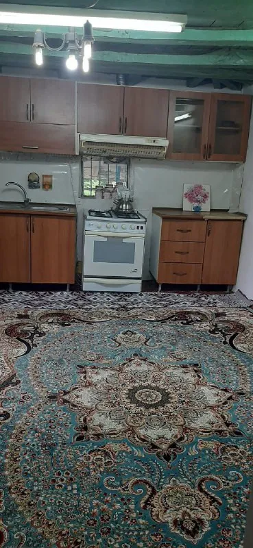 آشپزخانه با کابینت چوبی و فرش فیروزه‌ای