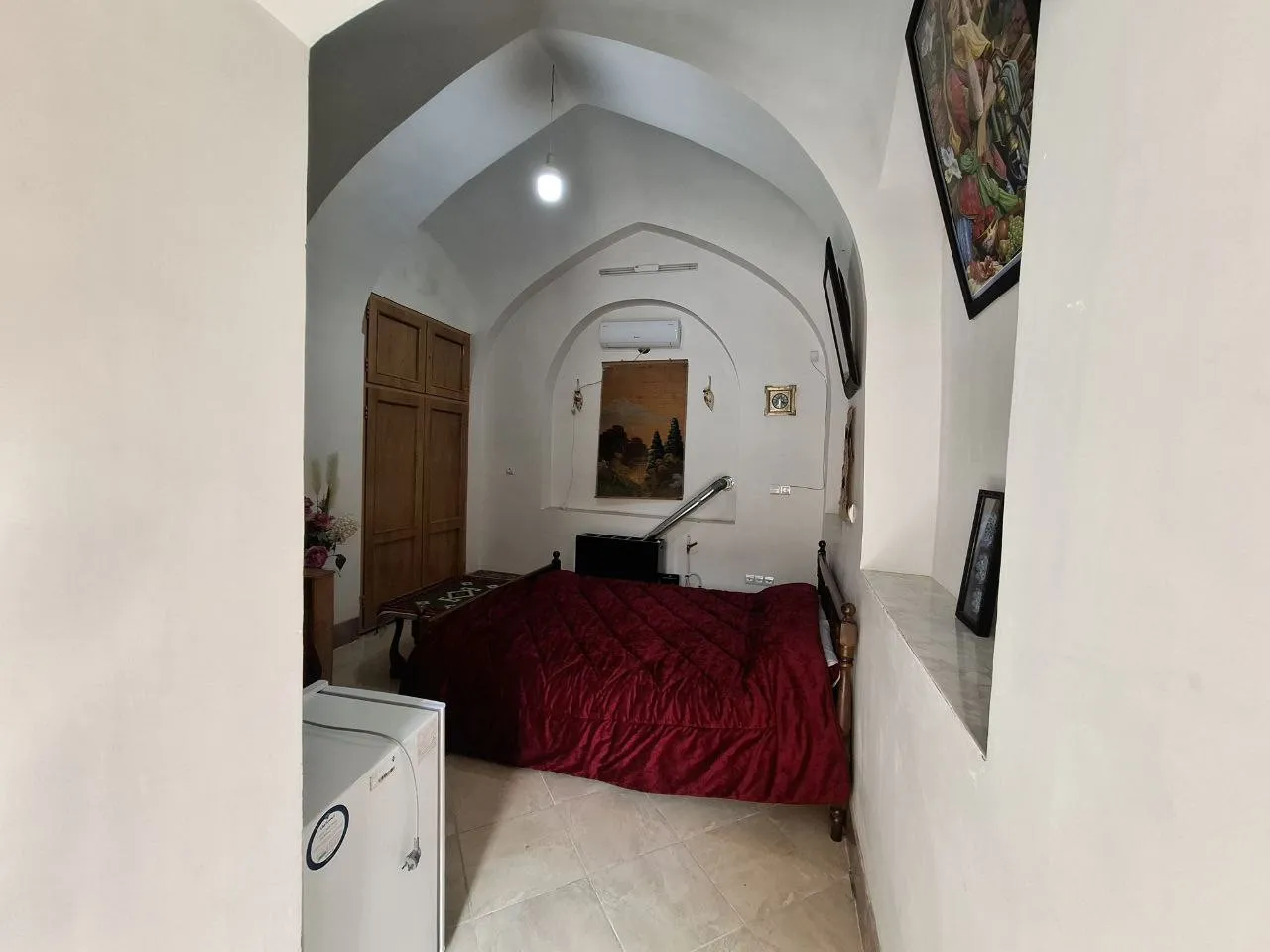 اتاق دیوان سالار با تخت دونفره و روتختی زرشکی