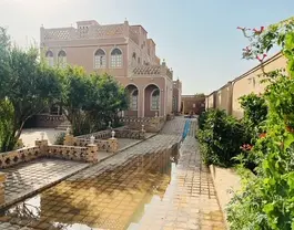 حیاط سنگ‌فرش هتل شمس العماره با بنای آجری
