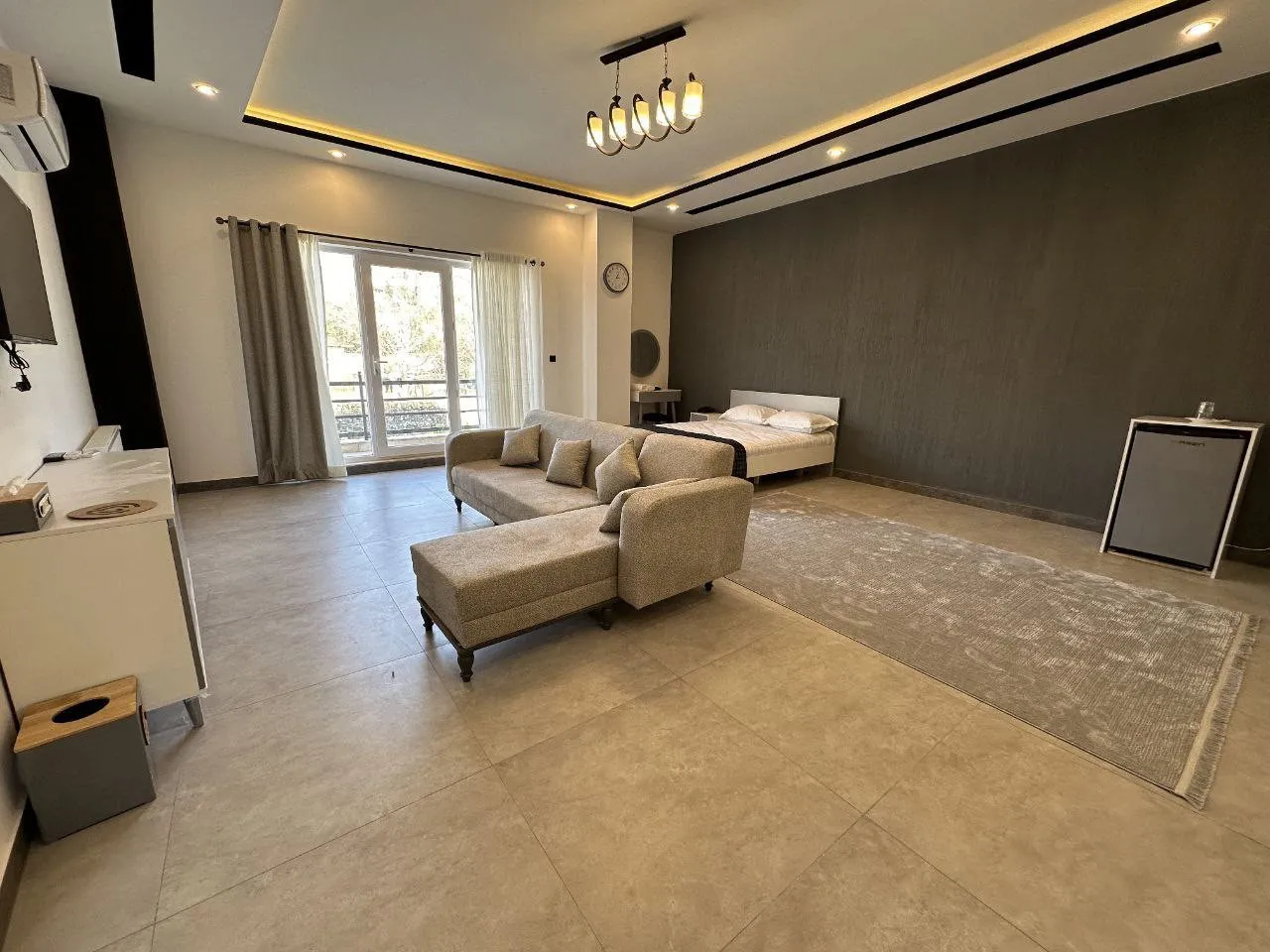 اتاق کابن با تخت، مبل ال‌شکل و پنجره بزرگ