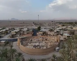 نمای هوایی قلعه خشتی بوم قلعه آریز در میان نخل‌ها