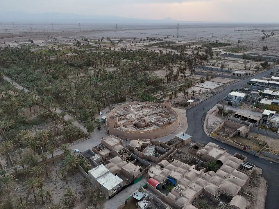 نمای هوایی بوم قلعه آریز میان نخلستان و روستا