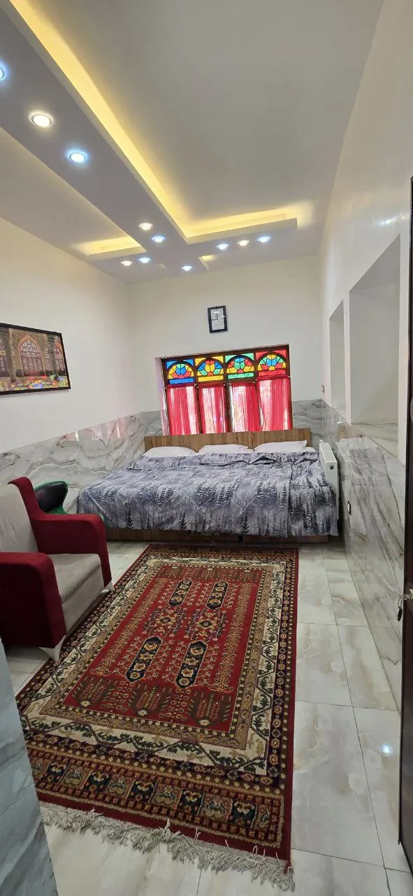 اتاق هتل نارنجستان با پنجره رنگی و فرش ایرانی