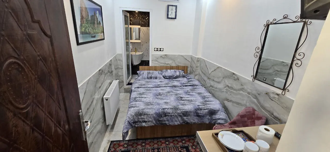 اتاق هتل نارنجستان با تخت دونفره و دیوار مرمری